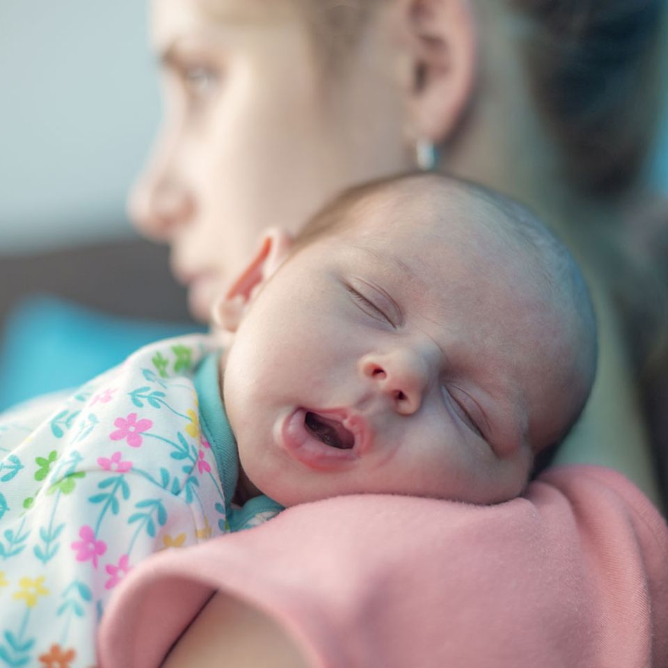 Debatte: Genervte Mutter mit Baby im Arm