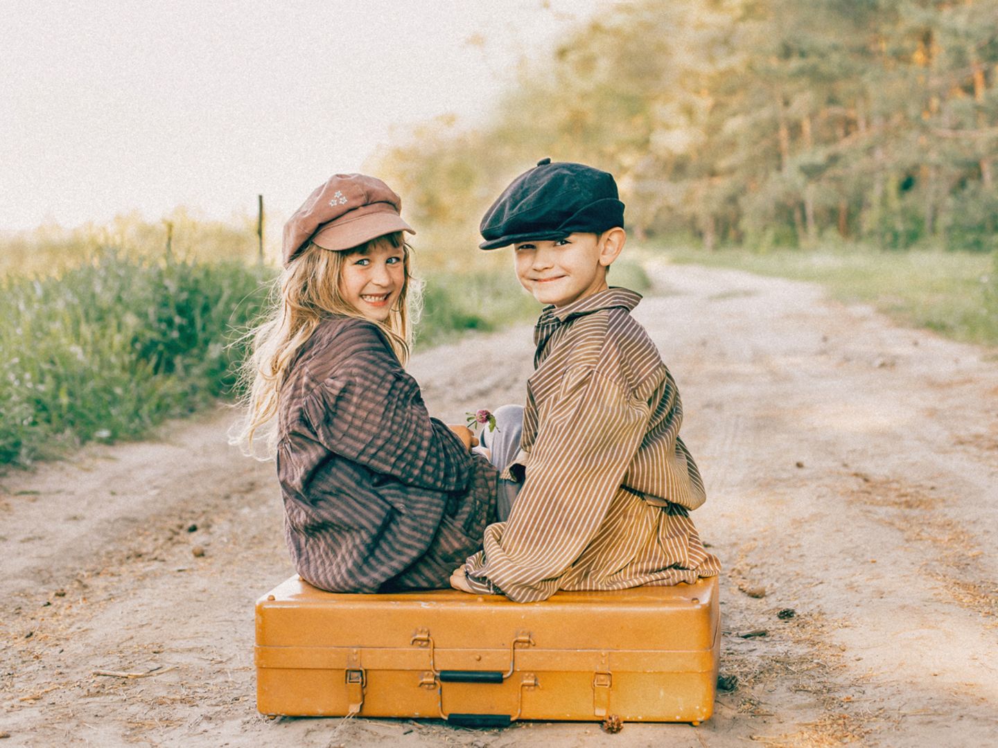 deutsche Jungennamen: Junge und Mädchen auf Koffer sitzend