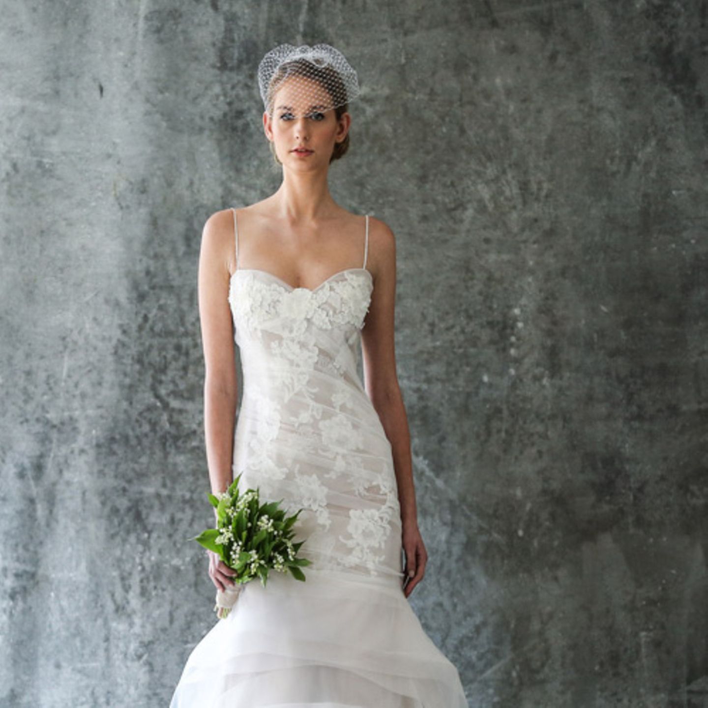 Hochzeitsfrisuren: Frau in Brautkleid mit Schleier und Brautstraß