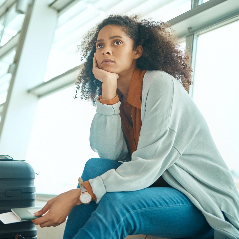 Gestresste Frau am Flughafen: Post-Holiday-Syndrom