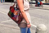 Kathleen, 19, imponiert uns mit einer bunten Tasche (Roland) im Schuppen-Muster. Ihre sommerliche, leicht geblümte Bluse (Vero Moda) kombiniert sie mit einem kleinen Tuch (Vero Moda), das sie am Hals zusammengebunden hat. Mit dem tollen Outfit lässt es sich gut durch den Sommer spazieren.