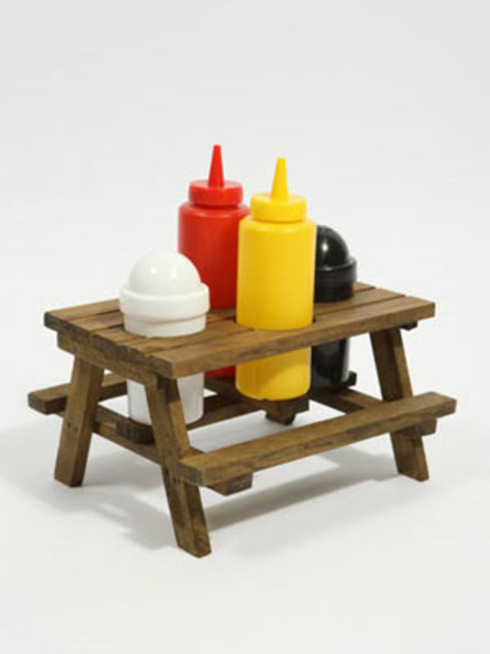Alles am richtigen Platz: Kleiner Holztisch (10,5 cm hoch) mit Ketchup- und Senfflaschen sowie Salz- und Pfefferstreuer. Von Urban Outfitters, um 26 Euro, über www.urbanoutfitters.co.uk