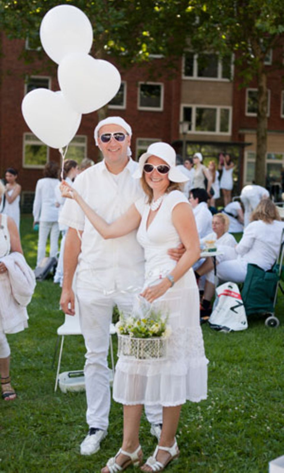 Ein besonders legeres Accessoire zum weißen Outfit: weiße Luftballons in Herzform.