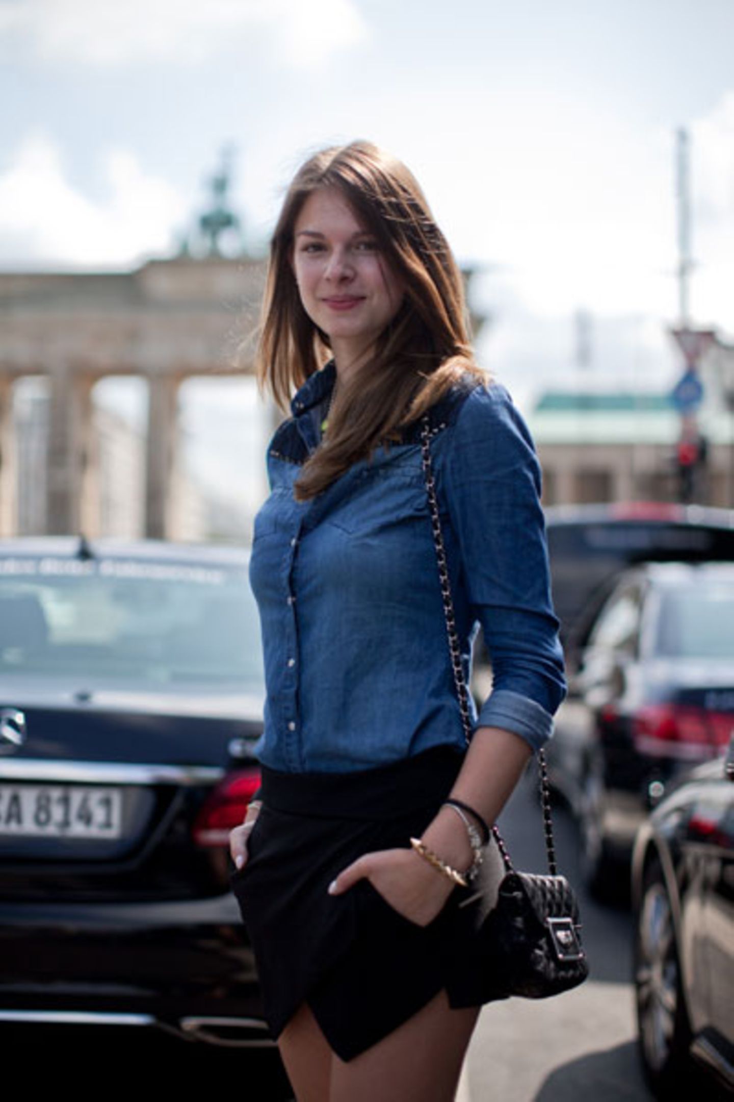 Warum kompliziert, wenn es auch einfach geht: Jeanshemd, interessant geschnittene schwarze Shorts und ein Umhängetäschen ergeben einen formidablen Fashion-Week-Look. Das Brandenburger Tor im Hintergrund macht sich dazu natürlich auch gut.