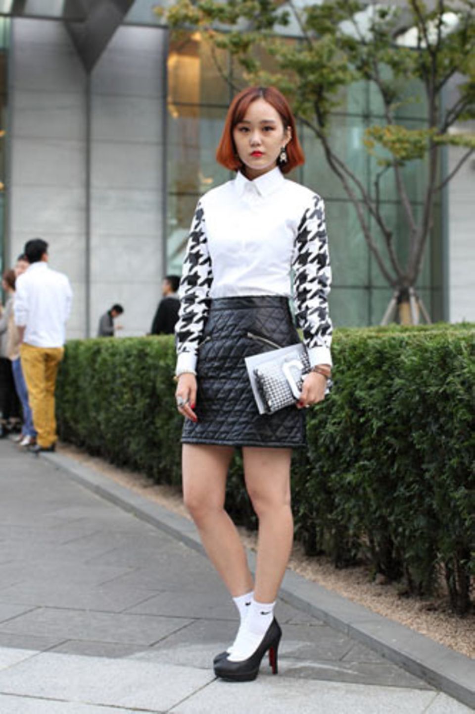 Wer hätte gedacht, dass weiße Tennissocken so schick sein können? Park Ji Gyung trägt sie zu Pumps, einem gesteppten Minirock und einer Pepita-Bluse mit passender Clutch (beides von Gluwa).