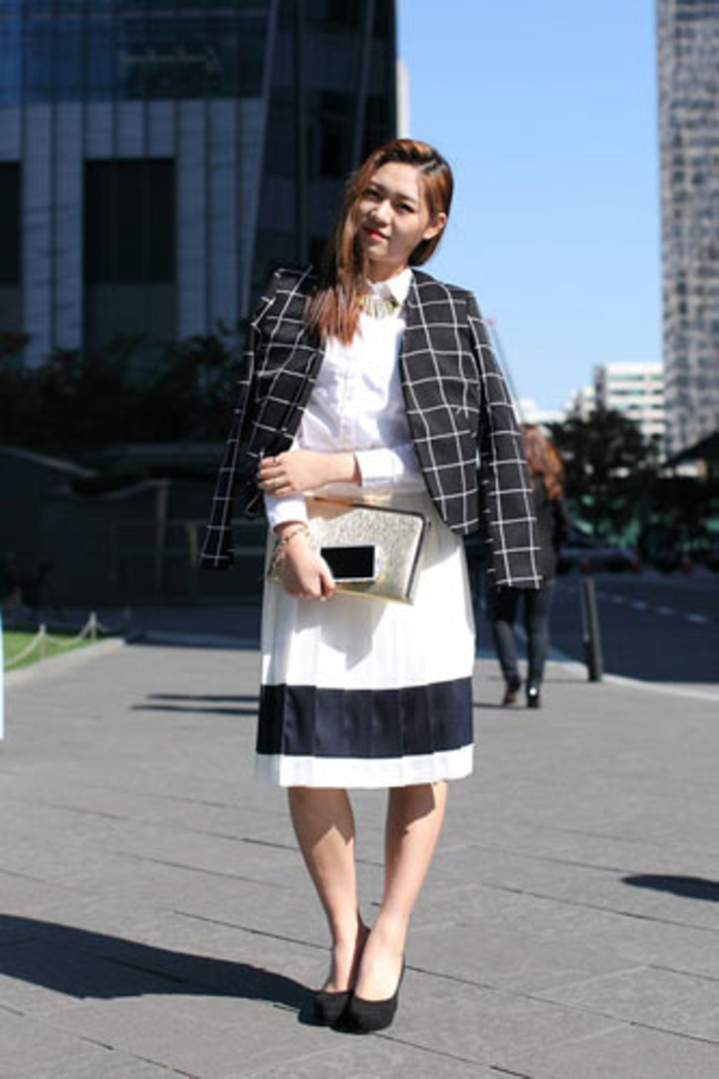 Schwarz-Weiß-Look Nummer drei: Kim Min Jeong wählt die bürotaugliche Variante mit einem Karo-Blazer von H&M, Faltenrock von Grace Raymond und einer weißen Bluse von Uniqlo.