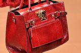 Bei Versace erinnert die Form der Henkeltasche an eine Doctor Bag. Das Material - knallrotes Schlangenleder - macht die Tasche luxuriös.