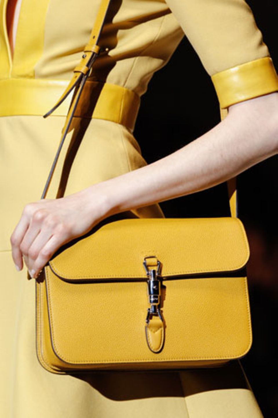 Schultertasche bei Gucci: ein sattes Gelb trifft auf robustes Strukturleder und raffinierte Verschlüsse.