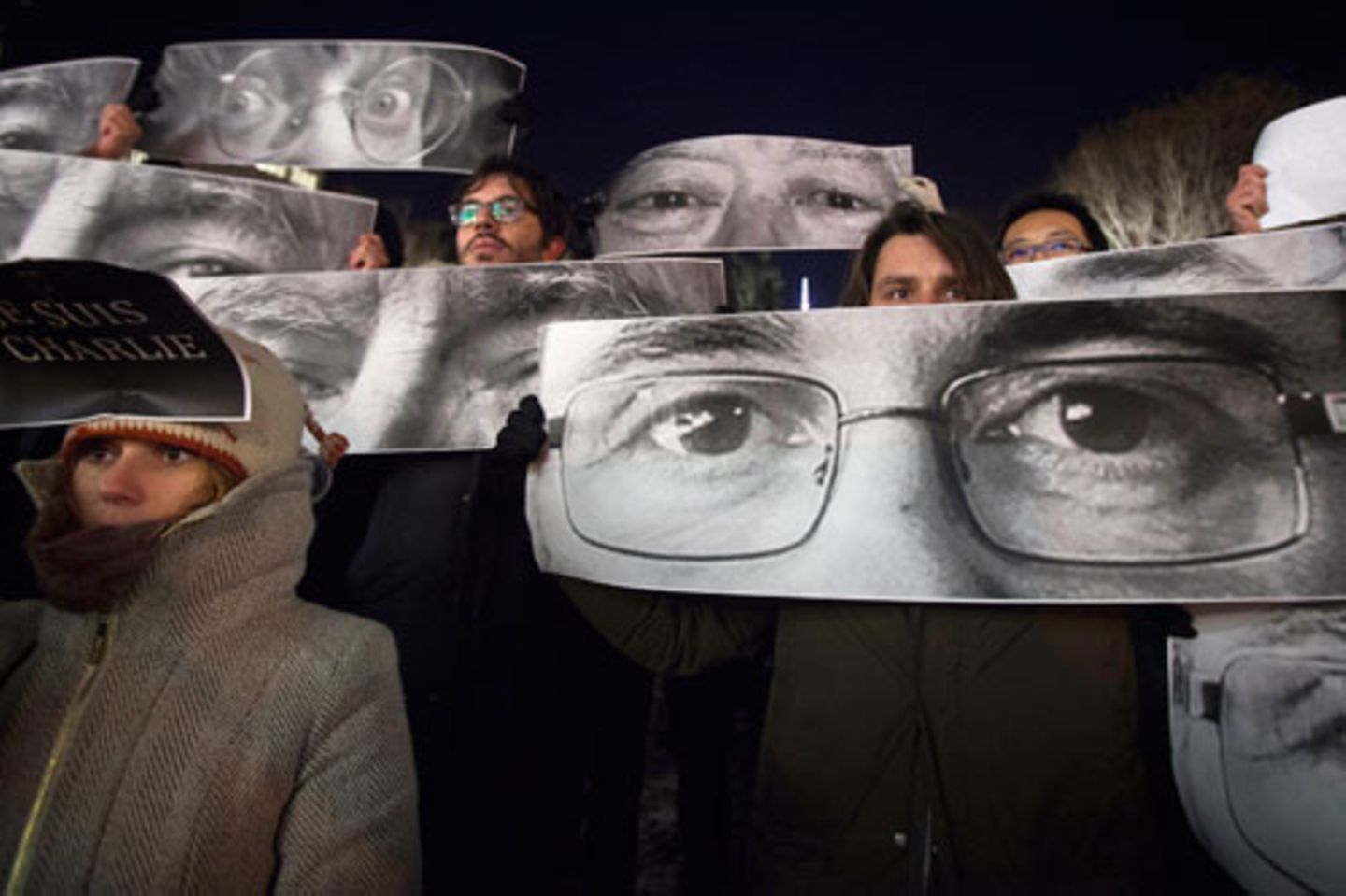 Auch Fotos der Opfer wurden auf Plakaten hochgehalten. Hier zu sehen: Die Augen der Karikaturisten Stephane Charbonnier (Künstlername "Charb", vorne) und Jean Cabut (Künstlername "Cabu", hinten links).