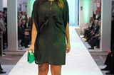 Esther trägt ein kurzes, dunkelgrünes Kleid von Very by Vero Moda, eine knallgrüne Tasche von Abro und Plateau-Sandalen von Buffalo.
