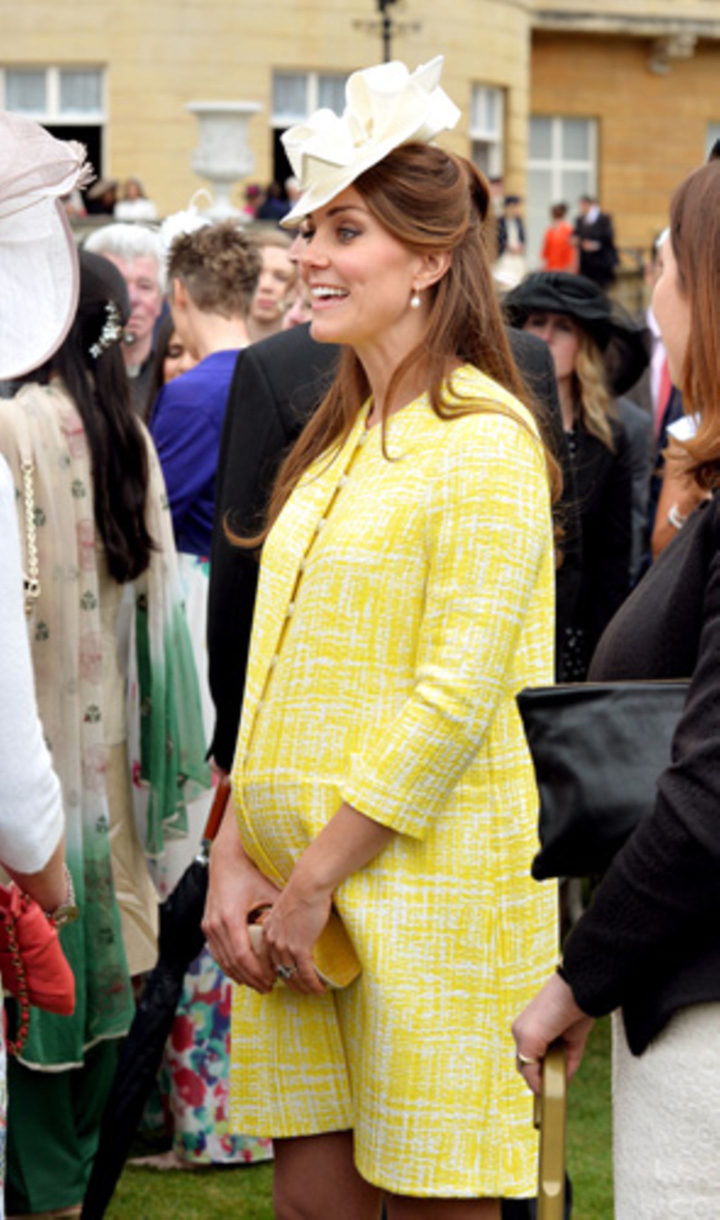 Was trägt man, wenn die Schwiegermutter (in Kate Middletons Fall also Queen Elizabeth II) zu einer Gartenparty einlädt? Im Buckingham Palace natürlich Hut – und einen sonnengelben Mantel.