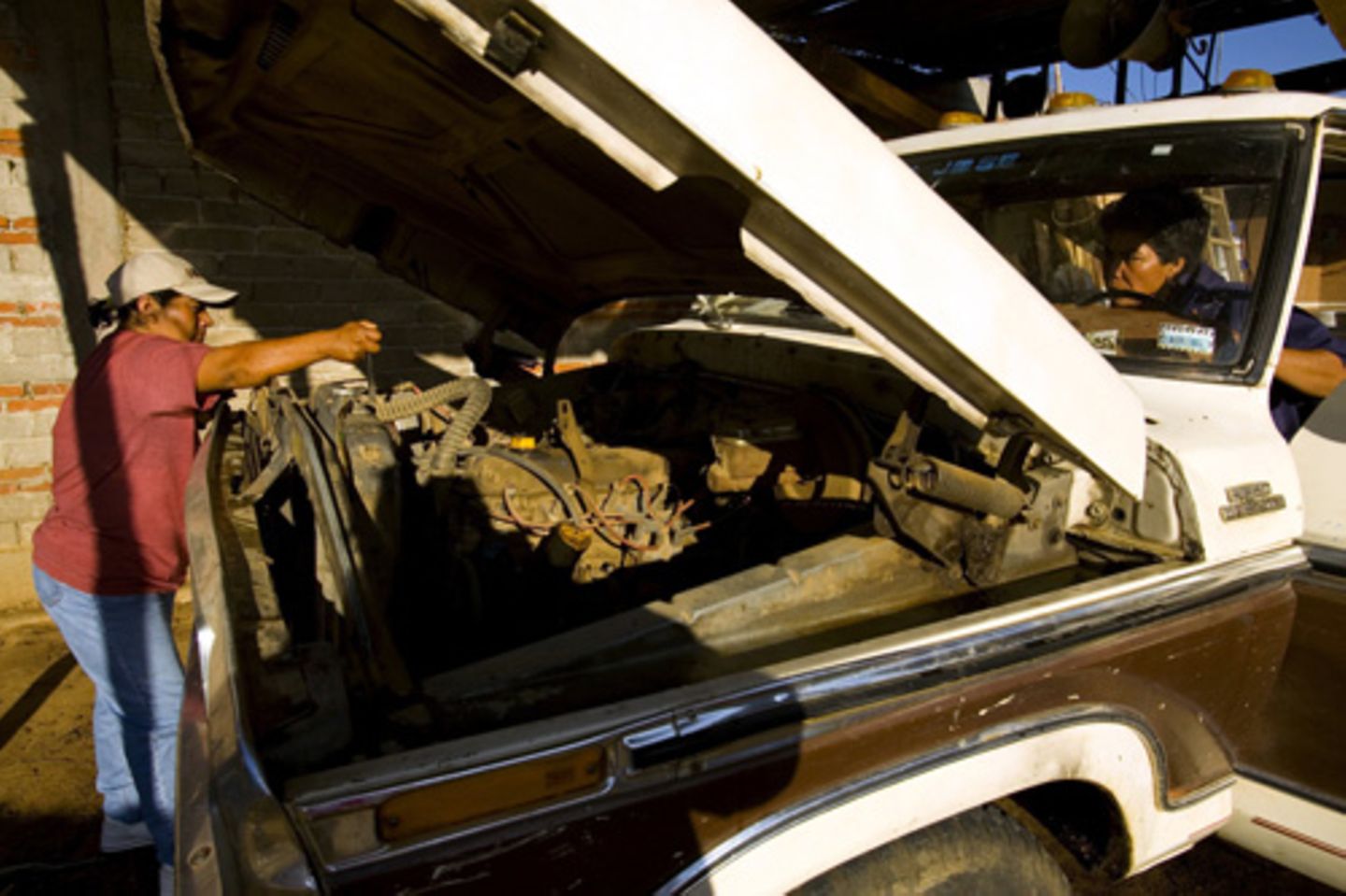Oaxaca, Mexico: Zwei Frauen reparieren ihren kaputten Truck, damit sie weiter Holz ausfahren können. Die Ehemänner der Frauen sind in die USA ausgewandert und haben ihre Frauen im Stich gelassen - wie viele andere Männer auch. Die Frauen ernähren nun allein ihre Familien, indem sie die Jobs der Männer übernehmen.