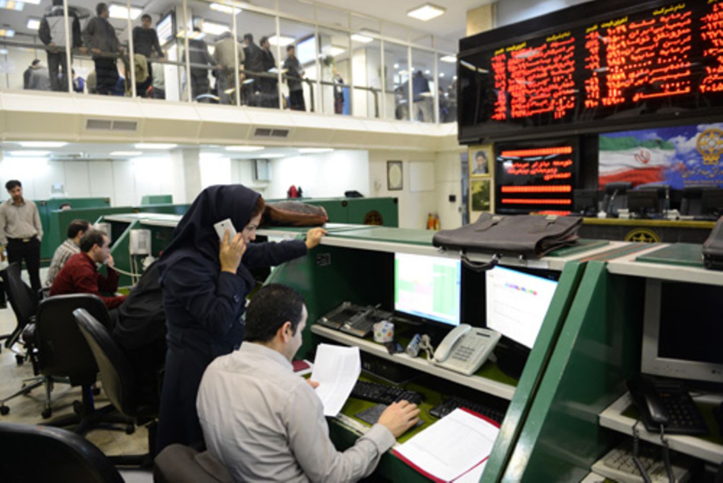 Teheran, Iran: Eine Börsenhändlerin diskutiert am Telefon über die aktuellen Kurse.