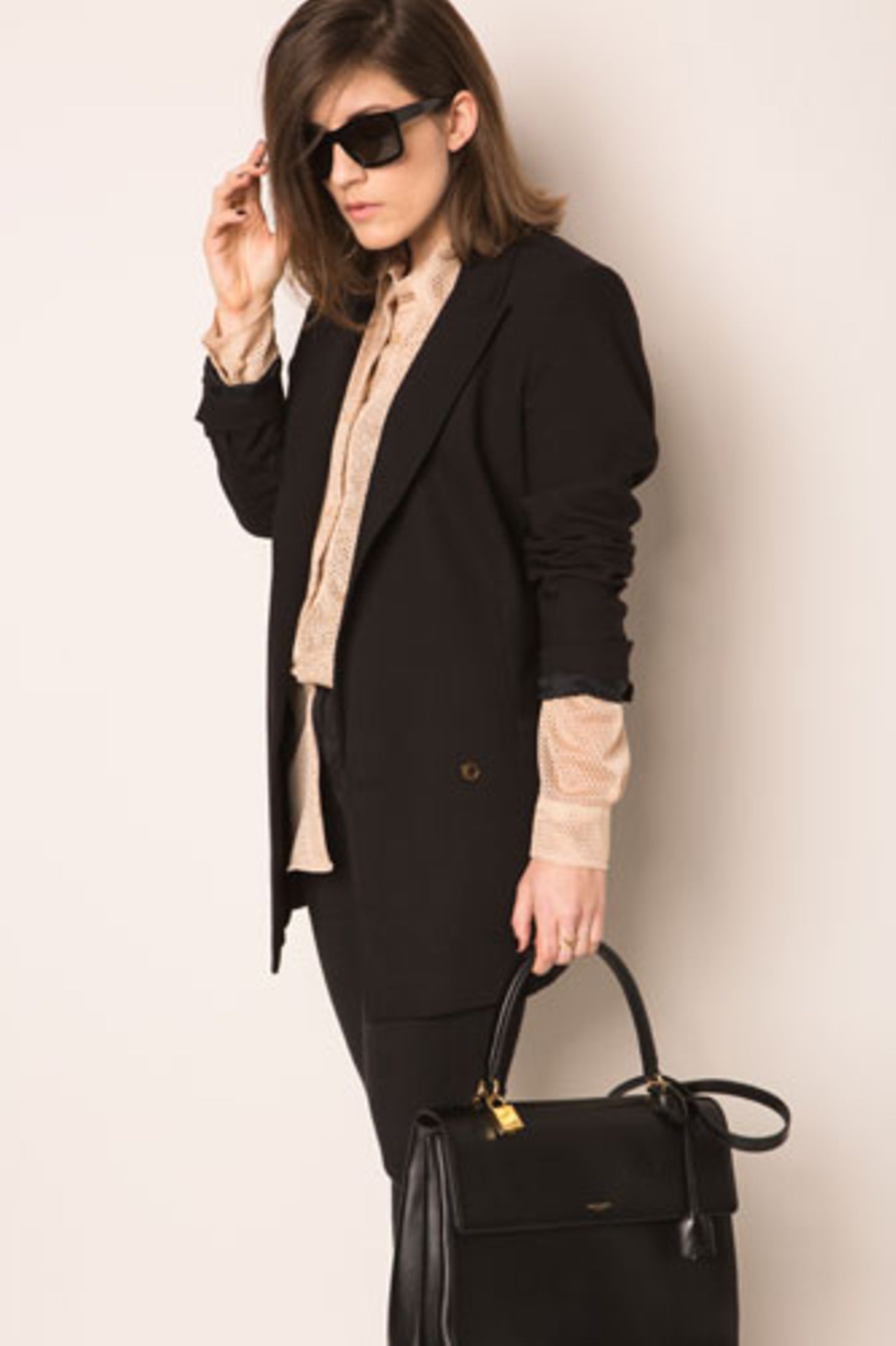 Carolas zweiter Look: eine lässige Kombi aus schwarzem Blazer, cremefarbener Bluse und Sonnenbrille.