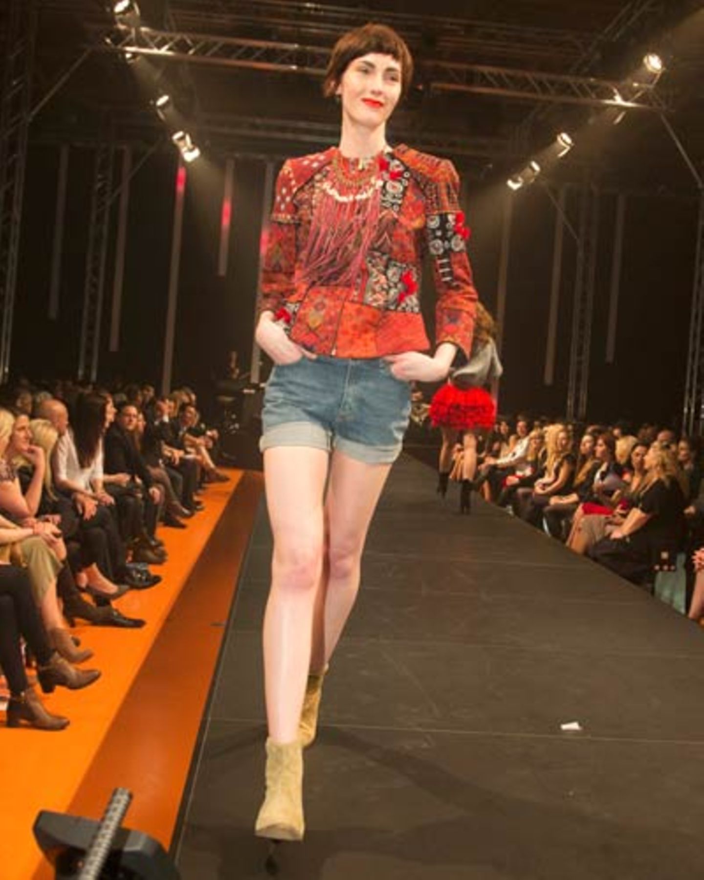 Die bunte Weste ist von H&M, das Top von Mey. Jeans-Shorts gesehen bei TK Maxx. Kette: Bijou Brigitte. Schuhe: Gabor.