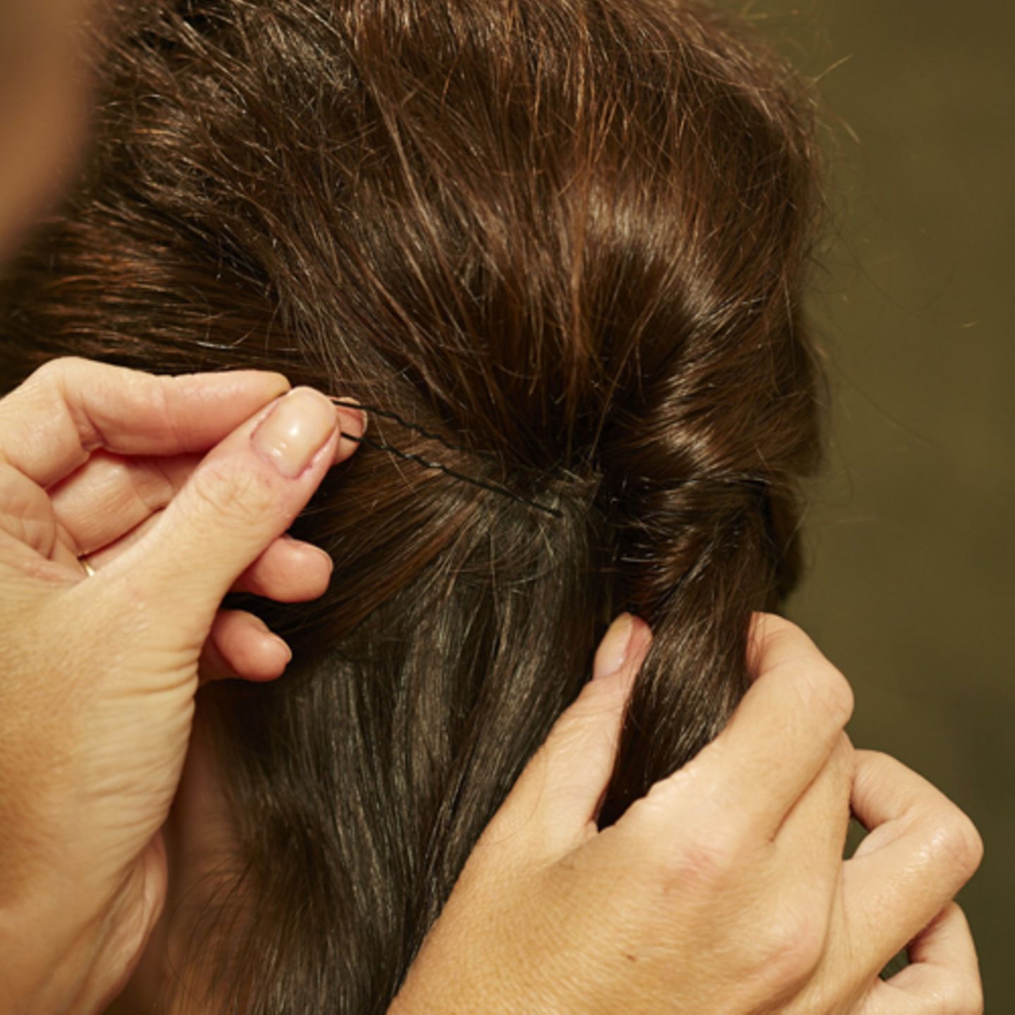 Stück für Stück weiter nach unten einschlagen. Am Ende die Haare zu einem Zopf zusammenbinden und mit einer Strähne das Haargummi umwickeln. Gut mit Haarspray benebeln.