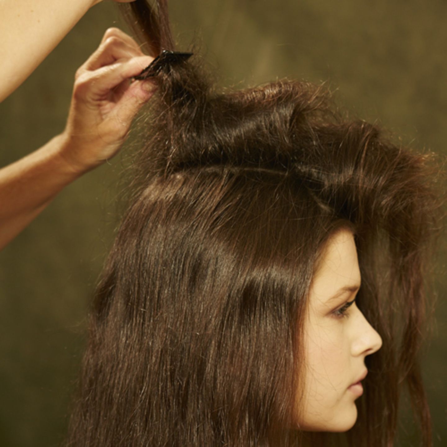Einen Mittelscheitel ziehen und die Haare auf einer Seite mit Haarspray und Kamm antoupieren.