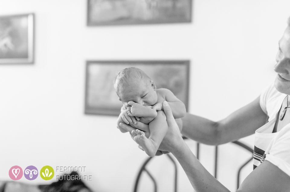 Eine : Mit sicherem Griff hält die Hebamme das Baby, das automatisch wieder die gewohne Position einnimmt.