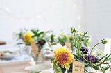 Gläser mit Blumen als Tischdeko