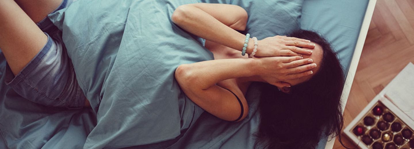 Dinge tun nach Trennung: Frau liegt traurig auf dem Bett