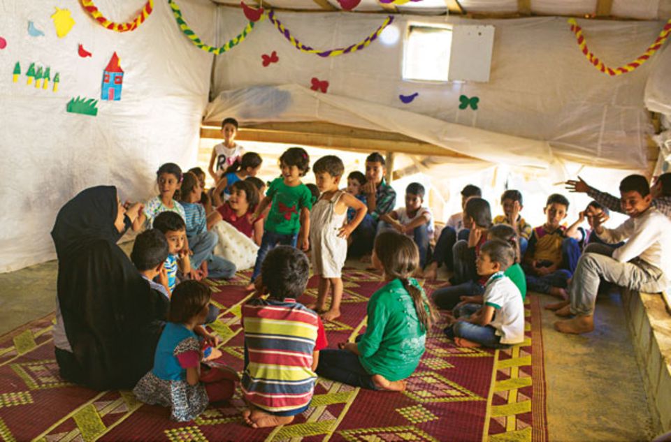 Rula (links) ist eine der Leiterinnen des Kinderraums im Camp. Hier sollen die Kinder nach der Flucht stabilisiert werden. Manche brauchen Wochen, bis sie sich allein hierher trauen. Ansonsten gibt es für sie keine kindgerechte Beschäftigung im Camp. Viele arbeiten mit sechs Jahren bereits auf dem Feld.