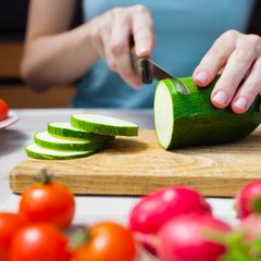 Gesunde Ernährung: Frau schneidet Zucchini