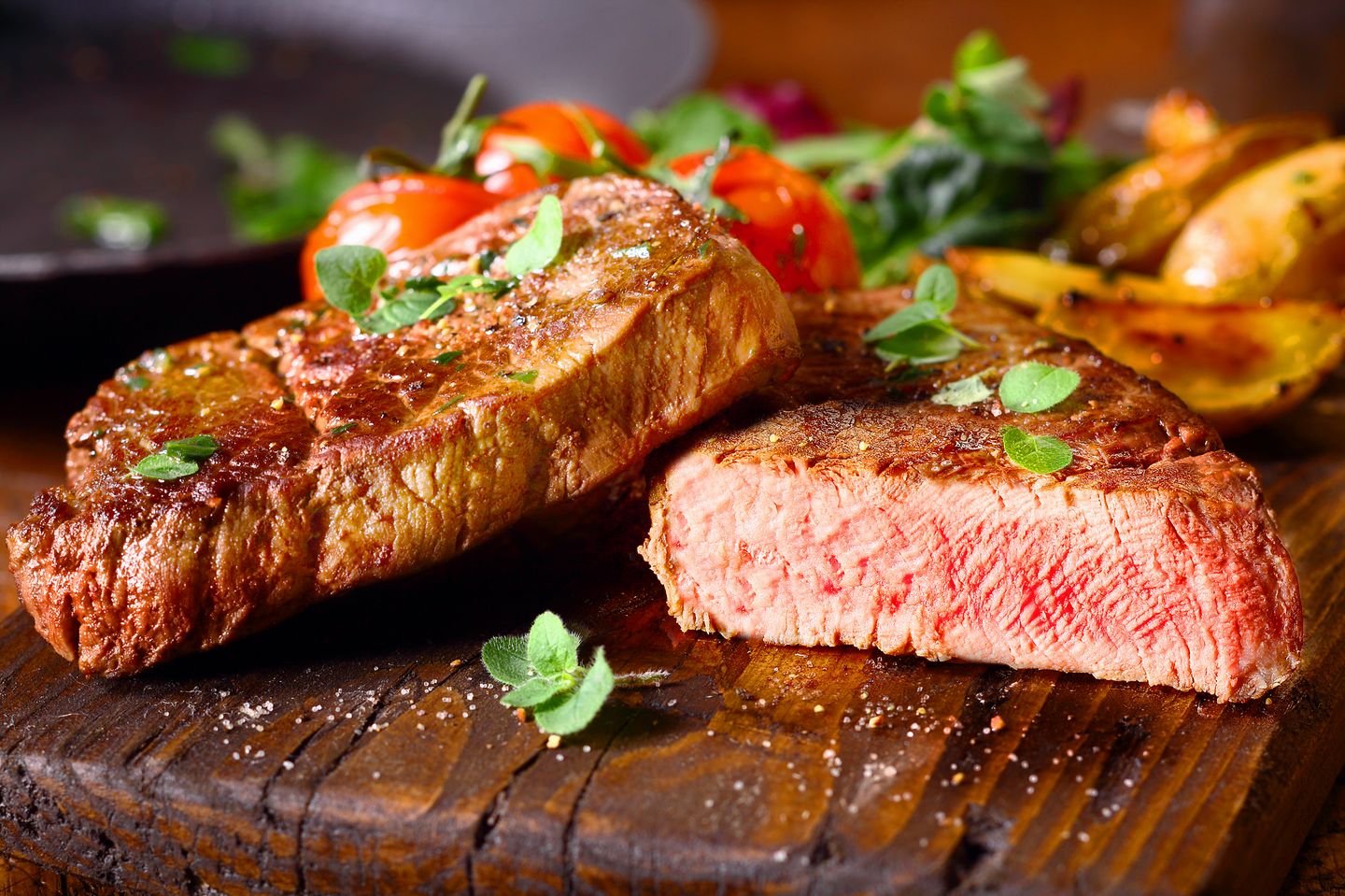 Schnelle Fettverbrenner: Ein aufgeschnittenes Steak, garniert mit Kräutern und Tomate