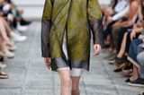 Der Designer Vladimir Karaleev, der in Japan sehr erfolgreich ist, schickt ein Model in einem transparenten Mantel über den Runway.