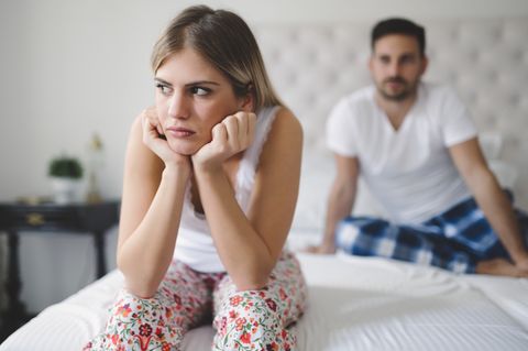 Partner verletzen: Paar sitzt auf Bett