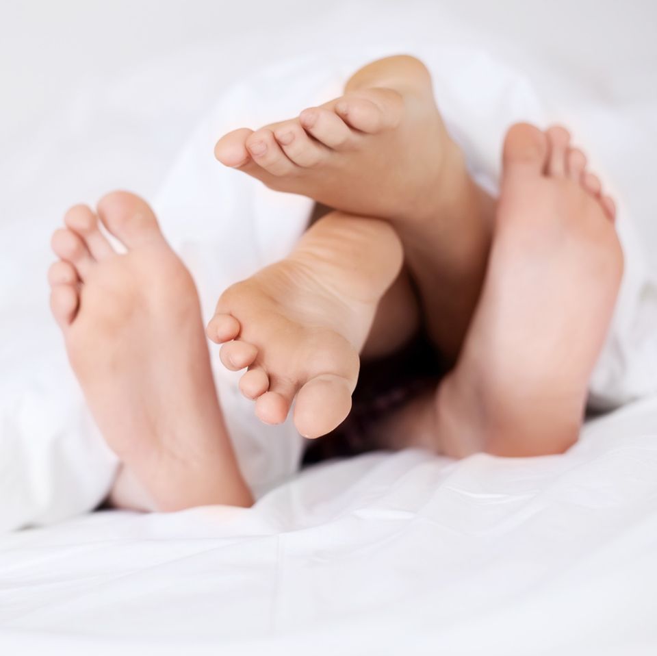 Pille absetzen: Zwei Paar Füße unter einer Bettdecke