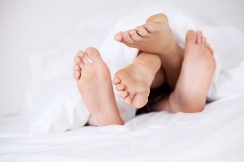 Pille absetzen: Zwei Paar Füße unter einer Bettdecke