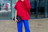 Bloggerin Caro Daur trägt einen roten Hoodie zu knallblauer Hose