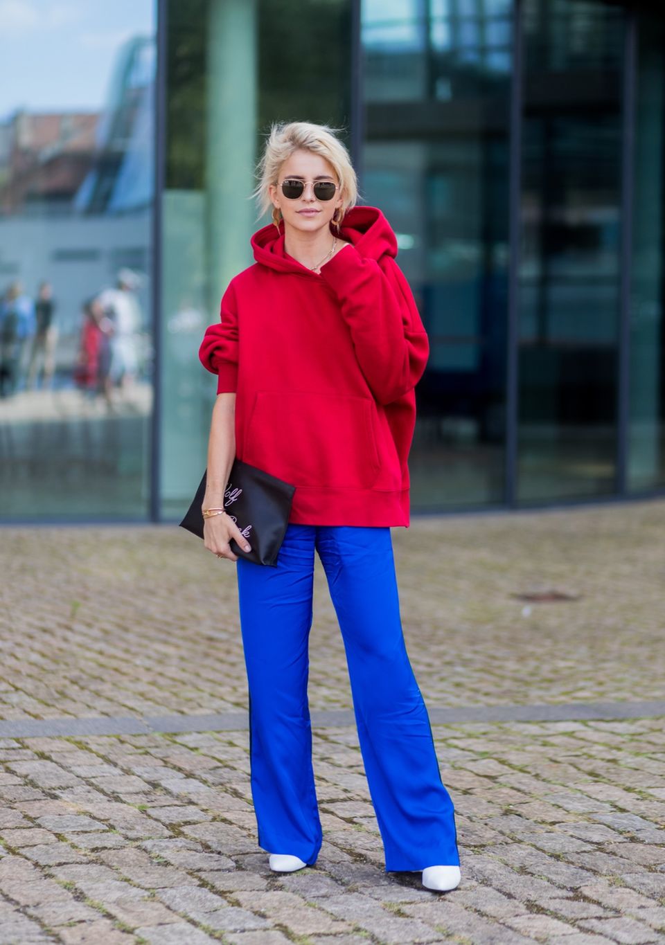 Bloggerin Caro Daur trägt einen roten Hoodie zu knallblauer Hose