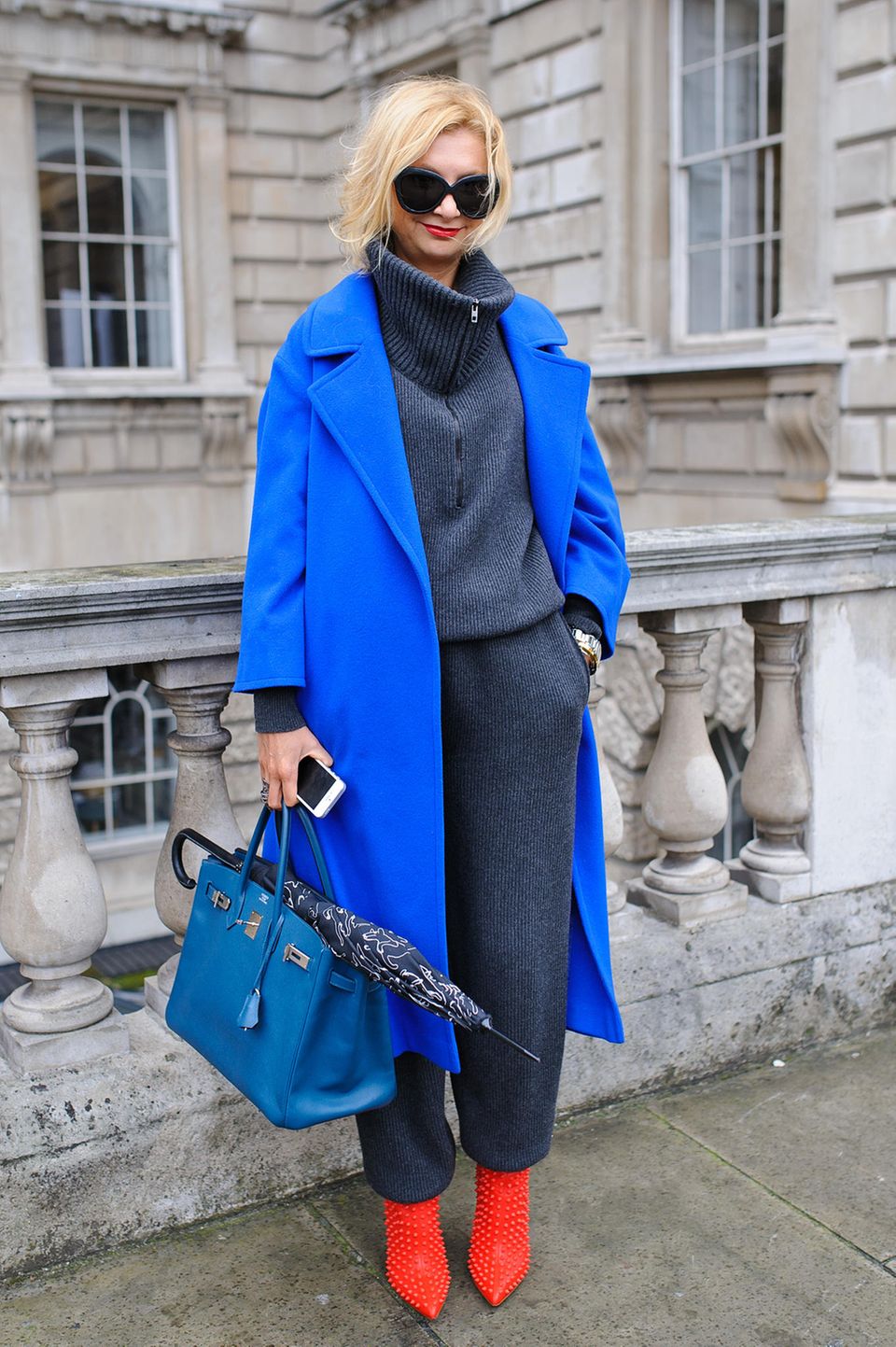 Bloggerin trägt royalblauen Mantel zu roten Schuhen