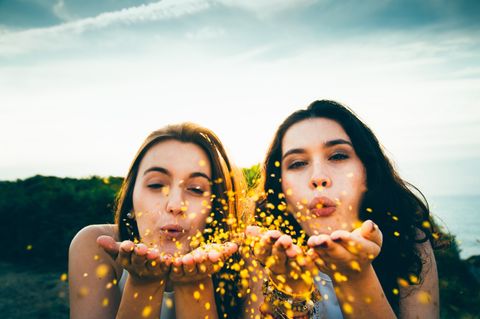 Zwei Frauen pusten Glitzer umher