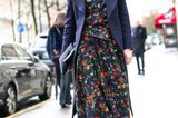 Bloggerin trägt silberne Stiefel zu Blumenkleid und langem Mantel