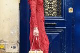 Helena Bordon in einem roten Midikleid und roten Stiefeletten