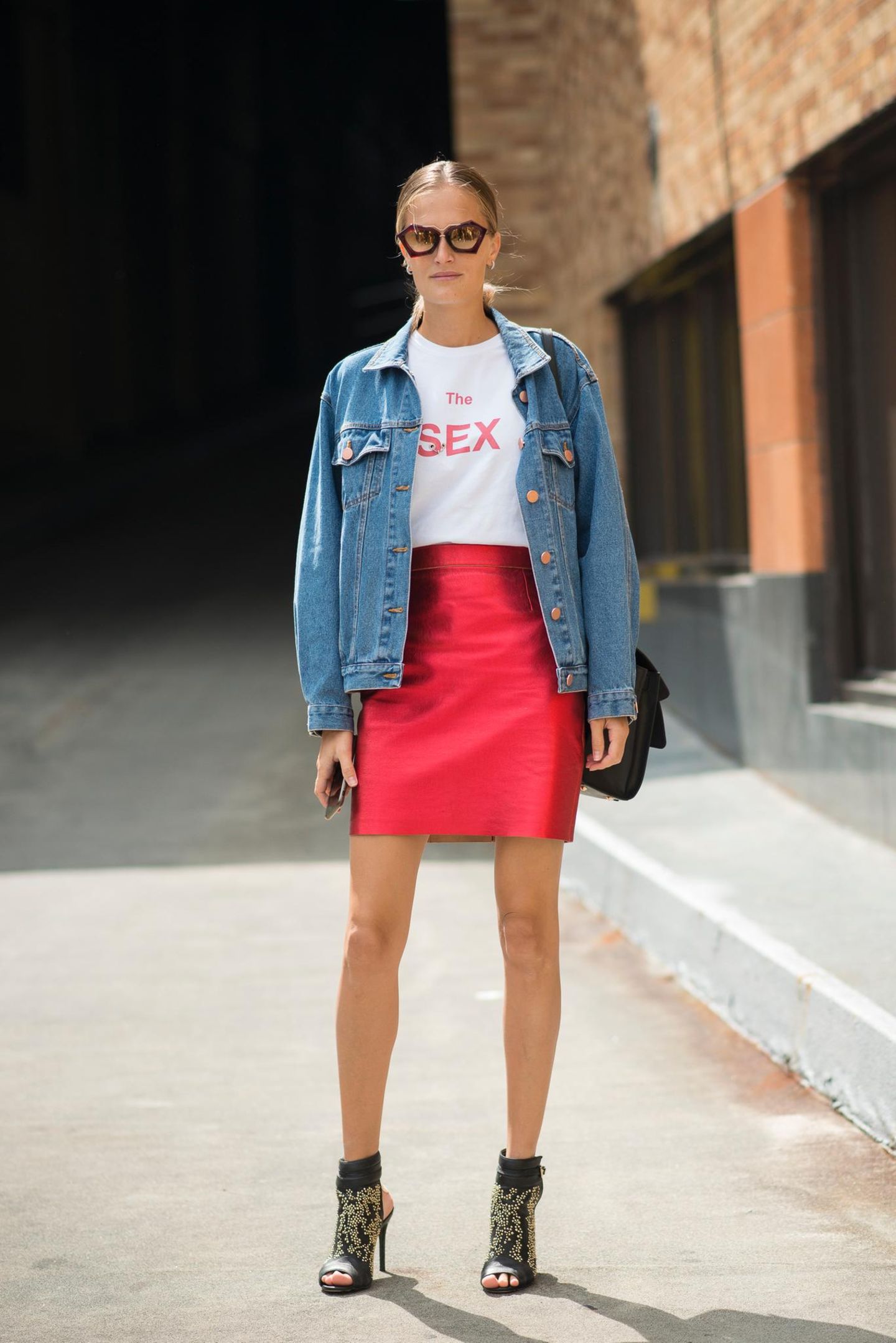 Bloggerin trägt roten Mini zu Statement-Shirt und Oversize-Jeansjacke