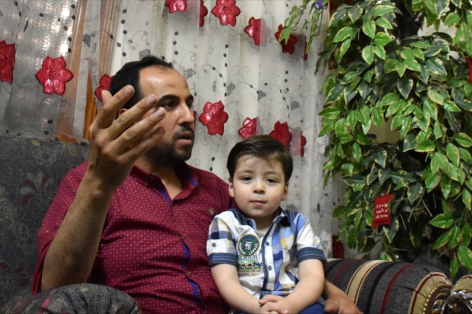 Omran Daknisch: Junge sitzt auf Schoß des Vaters