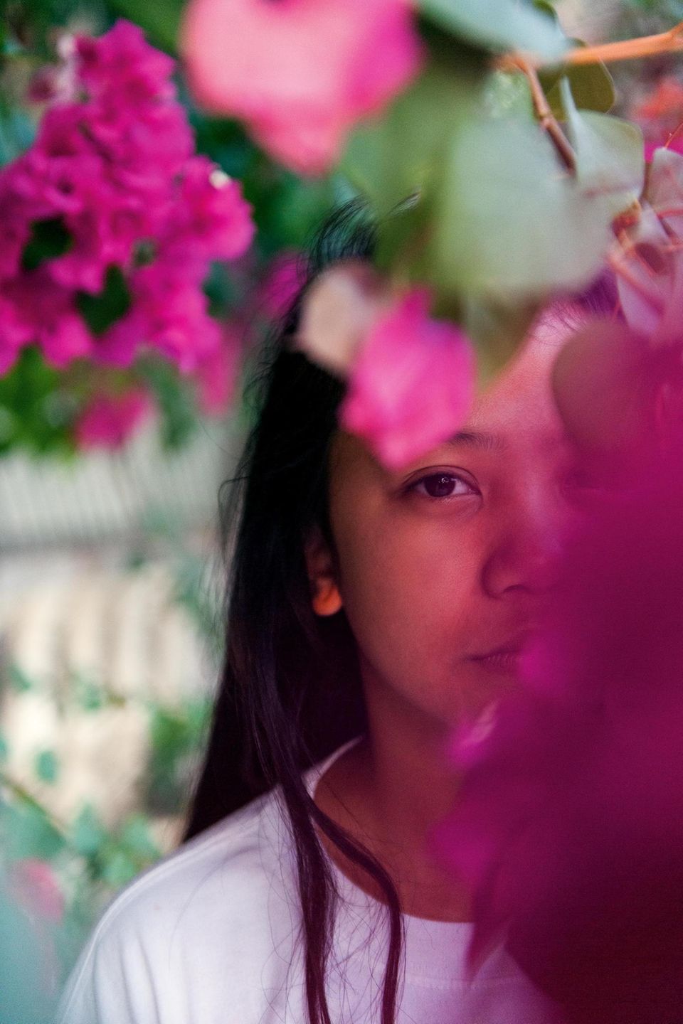 Ein Mädchen, das hinter Blumen posiert
