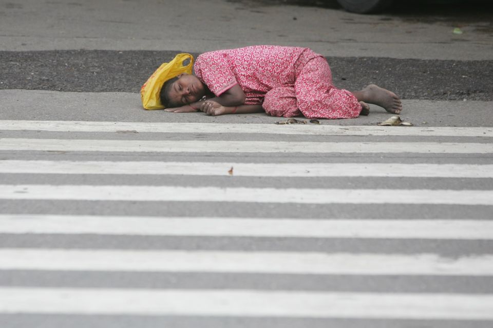 Ein Kind schläft auf einer Straße.