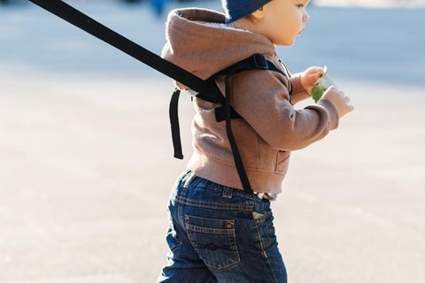 Ein kleiner Junge ist an eine Laufleine gebunden (Symbolbild).