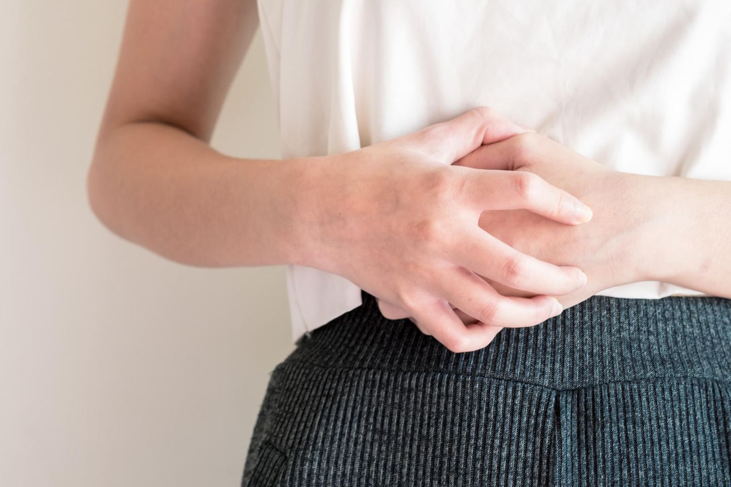 Endometriose: Frau hält beide Hände an ihren Unterleib