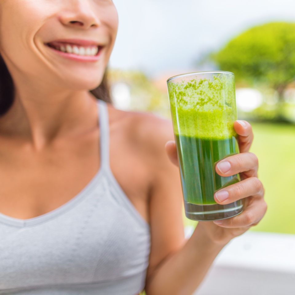 Kollagendrink: Frau hält grünen Smoothie in der Hand