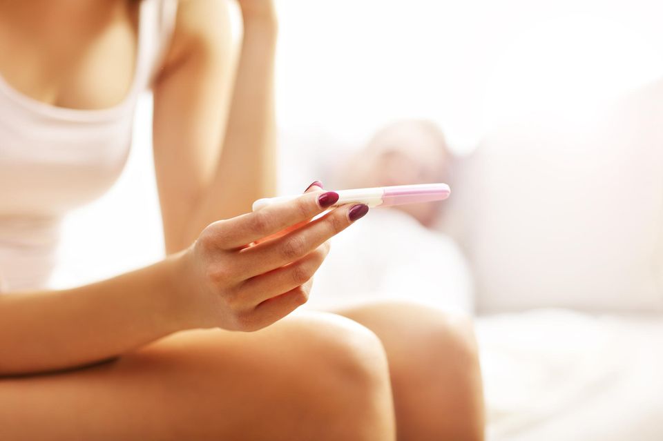 Ab wann Schwangerschaftstest: Frau hält Urintest in den Händen