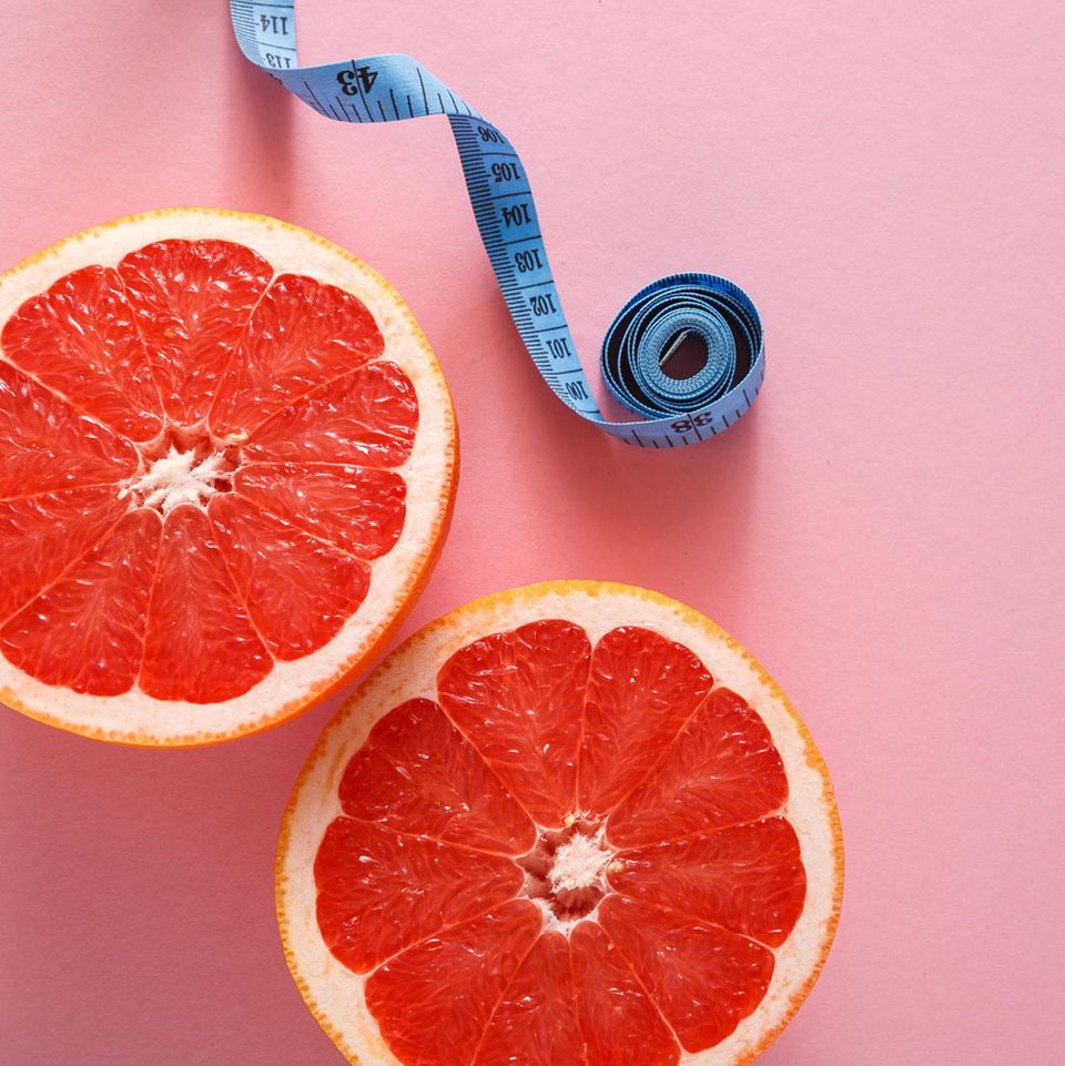 Nulldiät: Grapefruits und Maßband auf pinkem Hintergrund