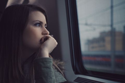 Frau schaut nachdenklich aus Zug – Depression