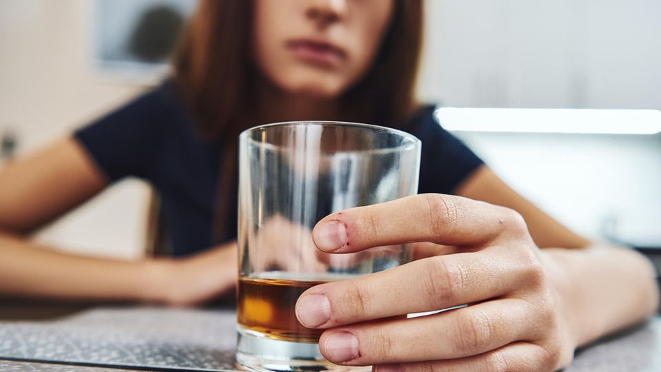 Alkohol-Allergie: Auf diese Symptome müsst ihr achten! Alkohol-Allergie: Frau hält Drink und fühlt sich sichtlich unwohl