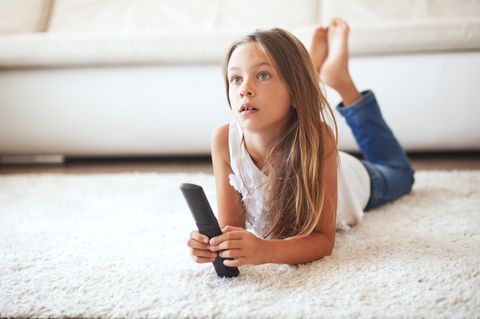 Mädchen vorm Fernseher mit Fernbedienung