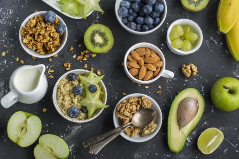 Glyx Diät: Schalen mit Müsli, Nüssen und Beeren auf dunklem Untergrund